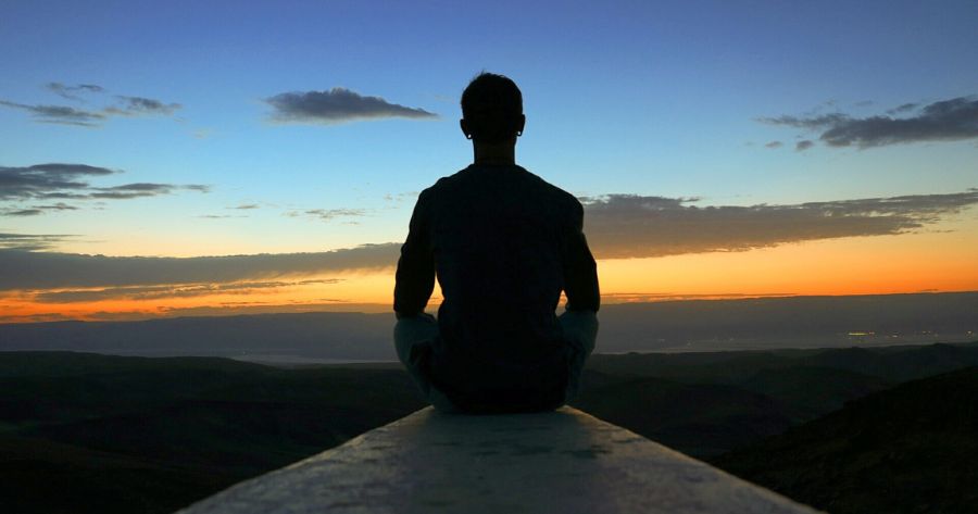 uomo seduto al tramonto mindfulness e meditazione